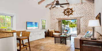 Coriander Cottage has a high cathedral ceiling in the living room and French doors leading out to the pool deck.