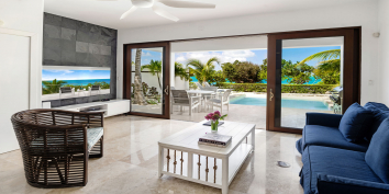 Large doors open from the living to the pool deck at Ocean Edge Villa, Turks and Caicos Islands.